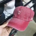 Detailansicht einer verwaschenen roten Vintage-Baseballkappe mit weißem Stickereilogo - Weinrot Mit Buchstabe C