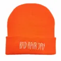 Leuchtend orangefarbene Strickmütze mit weißem BAD HAIR DAY Stickerei auf dem Umschlag - Verstellbar / Orangerot