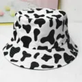 Gros plan détaillé du motif vache noir et blanc sur un chapeau bob en coton décontracté - Taille unique / Imprimé Vache Blanc