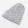 Detalle de la textura acanalada gruesa de un gorro de punto gris para el invierno - Gris claro