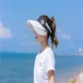Asiatisches Model mit stilvoller weiß-schwarzer Sonnenblende am sonnigen Strand - Gestreifter Stil (20-5) / Weiß