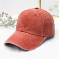 Nahaufnahme einer verwaschenen, terracottafarbenen Baumwoll-Basecap mit gebogenem Rand. - 55-60cm / Orange
