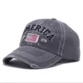 Nahaufnahme einer grauen Vintage-Baseballkappe mit Amerika-Stickerei und US-Flagge. - Zerrissen / Grau