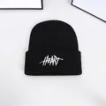 High-quality close-up of a black knitted beanie featuring white HEART embroidery detail - One Size / Embroidered Letter Beanie / Black