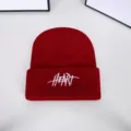 Detailed macro shot of a red knitted beanie with white HEART embroidery for winter wear - One Size / Embroidered Letter Beanie / Burgundy