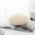 Weiche beige Wollbaske auf einem offenen Magazin in einer hellen Umgebung - Beige