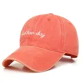 Détail de la casquette en coton lavé avec texte bad hair day brodé en rouge vintage. - Orange