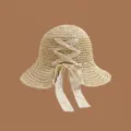 Nahaufnahme eines handgewebten Strohhutes mit einer Spitzen-Schleife - Erwachsene 56-58 / Kreuzknoten Beige