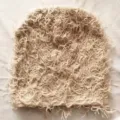 Detailed close-up view showing the shaggy and textured fabric of the fuzzy knit beanie - One Size / All Beige