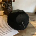 Macrodetail van een zwarte gebreide muts met metalen ringen en een veiligheidsspelddecor - Zwart