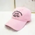 Primo piano di un berretto da baseball in cotone rosa con ricamo nero 1995 sulla fronte. - Berretto 1995 / Rosa