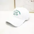Dettaglio del cappello da baseball bianco con ricamo verde 1995 in cotone morbido - Berretto 1995 / Bianco