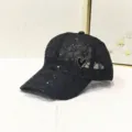 Detail einer schwarzen Netz-Basecap mit Pailletten und Herz-Emblem - Netzgewebe Herz Pailletten Stil / Schwarz