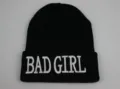 Détail de la broderie 3D blanche 'BAD GIRL' sur un bonnet en acrylique noir tricoté - Réglable / Black (BAD GIRL)
