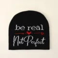 Dettaglio del testo lavorato a maglia 'be real Not Perfect' sul berretto nero - Motivo Cuore Be Real (3)