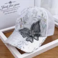 Primer plano de una gorra de malla con mariposa de diamantes y detalles de lentejuelas - Blanco