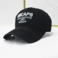 Nahaufnahme einer gewaschenen schwarzen Baseballkappe mit weißer OSCAPS-Stickerei - Verstellbar / Gewaschenes Schwarz