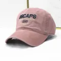 Nahaufnahme einer Vintage gewaschenen rosa Baseballkappe mit 'OSCAPS' Stickerei. - Verstellbar / Gewaschenes Rosa