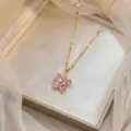 Close-up of an elegant gold necklace with a pink zircon floral pendant in a jewelry box - Pink-1 (X1590)
