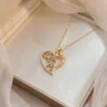 Dettaglio ravvicinato della collana con ciondolo a cuore dorato e zirconi colorati - Colorato