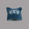 Details einer flauschigen Katzenohren-Strickmütze mit Schmetterlingsmotiv - Einheitsgröße / Schmetterling Dunkelblau