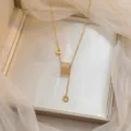 Detalle de elegante collar de oro con colgante cilíndrico de circonita en caja de regalo. - Estilo Colgante Cilindro (X0028)