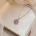 Vista detallada de un collar dorado con un elegante colgante redondo de circón lavanda. - Estilo Redondo Geométrico Púrpura (X0061)