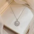 Gros plan élégant d'un pendentif fleur rotatif scintillant avec des zircons - Collier Fleur Rotative (X0687) / Argent