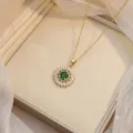 Detail view of gold sunburst pendant necklace with a brilliant green center stone. - Sun Flower Emerald Necklace (X0747)