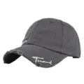 Nahaufnahme einer anthrazitfarbenen Baseballkappe mit Stickerei und ausgefranstem Rand. - Verwitterte Baseballkappe (20240229) / Dunkelgrau