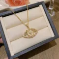Élégant collier en acier titane doré avec un pendentif œil serti de zircons. - Oeil du Mal (X0315)