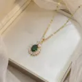 Elegant gold necklace with emerald-green oval zircon and sparkling floral pendant. - Oval Green Zirconia Gold Chain (X0434)