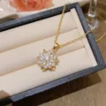Elegant gold plated sunflower pendant necklace with clear zircon stones in a jewelry box. - X0233 Five-Petal Sunflower Necklace / Gold