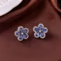 Detaillierte Ansicht eleganter blauer Edelstein-Blumenohrringe auf braunem Satin - Blaue Blume Ohrringe (E0192)