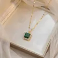 Gros plan détaillé d'un collier en or avec un pendentif carré en zircon vert émeraude. - Style Émeraude (X0951)