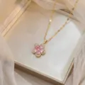 Elegantes Detail einer goldenen Halskette mit rosa Zirkon-Blumenanhänger in einer Box - Rosa Blumenhalskette (X0965)