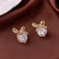 Detailansicht eleganter vergoldeter Zirkon-Schleifen-Ohrstecker auf braunem Seidenhintergrund - Goldene Schmetterling Ohrstecker (E0039)