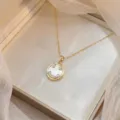 Nahaufnahme einer Goldkette mit einem Smiley-Anhänger, Zirkonia und Muscheleinlage - Smiley Perlmutt Halskette (X2969)