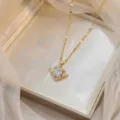 Nahaufnahme einer goldenen Herz-Halskette mit Engelsflügeln und großem Zirkonia - Herz Flügel Halskette (X0956) / Gold