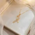 Collier élégant avec pendentif ruban doré et zircons étincelants taille baguette - Style Noeud Doré (X0963)