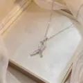 Collier élégant avec pendentif en ruban argenté et pierres en zircone cubique. - Style Noeud Couleur Acier (X0969)