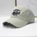 Detailansicht einer beige gewaschenen Baumwoll-Baseballkappe mit dunkelblauer Stickerei - Verstellbar / Stil A Beige