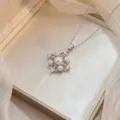 Macro view of a silver floral pendant with pearls and zircons on a satin box - Four-Leaf Pearl Pendant Necklace (X0860)
