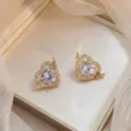 Détail rapproché de boucles d'oreilles cœur dorées avec ailes d'ange et zircons brillants - Cœur d'Ange Or (E0490)
