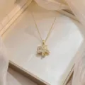 Gros plan détaillé d'un collier avec pendentif fleur doré orné de zircons scintillants - Fleur étoilée à 5 pétales (X0854)