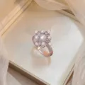 Detail of an elegant floral ring with central pearl and sparkling zircon stones - Four-Leaf Pearl Band Ring (J0553)