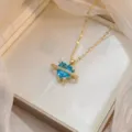 Vista detallada del collar dorado con piedra de corazón azul y diseño de anillo planetario. - Estilo Corazón Anillo Planetario Azul (X0988)