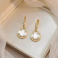 Vue rapprochée des élégantes boucles d'oreilles smiley en or avec nacre et zircons. - Visage Souriant Or (E0976)