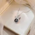 Vue détaillée du collier papillon argenté avec zircone noire facettée dans sa boîte cadeau - Hollow Butterfly Black Round Rhinestone Style (X0919)