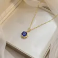Elegant gold chain necklace featuring a round blue sapphire-like gemstone pendant. - Dark Blue Round Gold Chain (X0437-3)